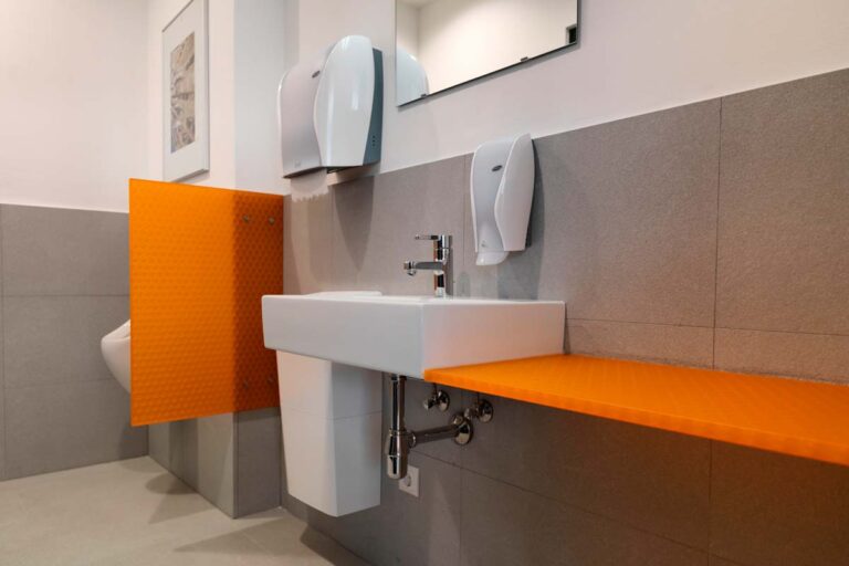 Orangefarbene Urinal-Trennwand, die Privatsphäre im Sanitärbereich bietet